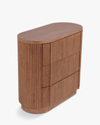 Commode élégante en bois avec coins arrondis, façade nervurée et système d'ouverture-pression pour chambre et salon