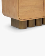 Buffet rétro en bois clair et bronze avec coins arrondis et pieds cylindriques pour salon