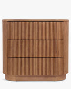 Commode élégante en bois avec coins arrondis, façade nervurée et système d'ouverture-pression pour chambre et salon